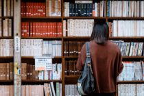 a woman in front of a bookshelf